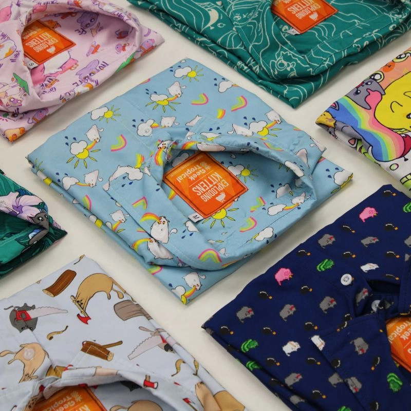 Colorful Geek Tropical Shirts with Exploding Kittens Designs laying down on the floor.