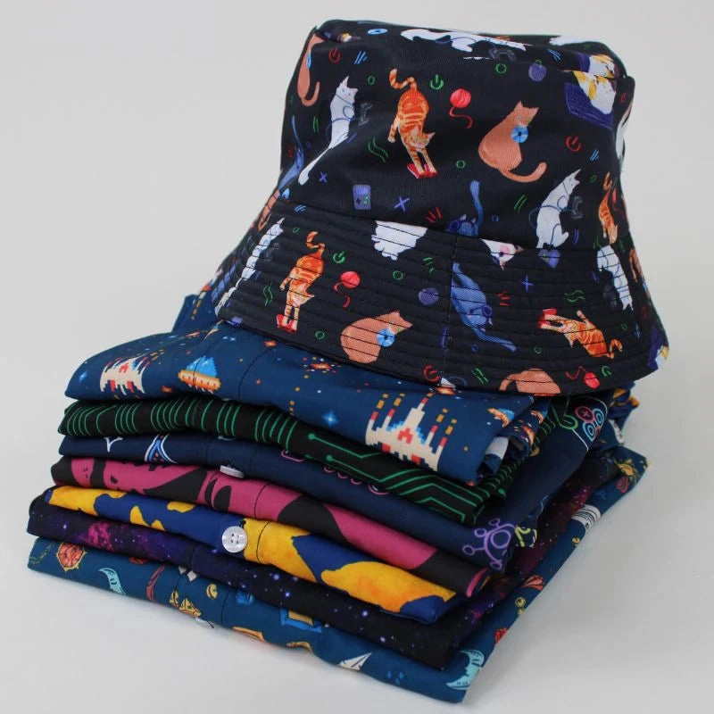Stacked bucket hats and shirts in dark prints