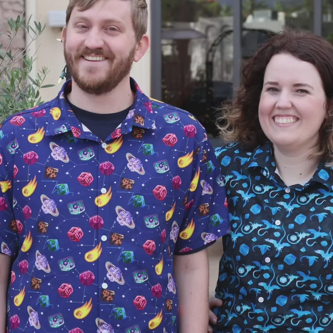 Smiling couple in matching navy button up shirts with colorful fruit prints